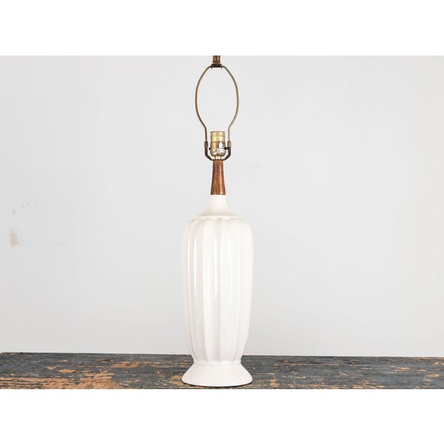 This elegant 1960s-era vintage table lamp features a fluted white ceramic body with a gently tapered shape, widening...