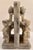 A pair of carved stone bookends featuring raised flower motifs, each panel showing a full bloom flanked by budding stems...