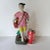 A 'famille-rose' porcelain figure of a Chinese revolutionary young woman. Standing on a gray base wearing a pink t-shirt...