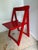Mid-century modern vintage folding wooden chair in fire-engine red with brass fasteners. Such a cool piece that would be...