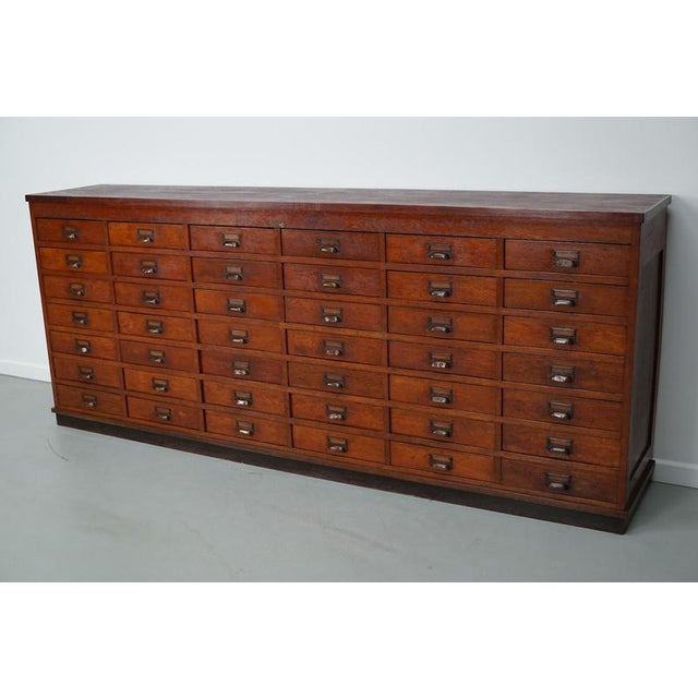 This apothecary / shop cabinet was produced during the 1930s in the Netherlands. It features 42 drawers with brass...