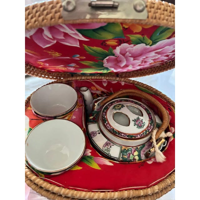 Chinese Rose Medallion Porcelain Tea Pot with two cups. The whole set is in a fabric floral lined woven carrying basket....