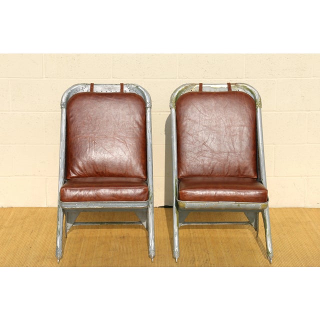 Wonderful pair of airplane chairs made of aluminum, and they have new brown leather seats and backs. They are originally...