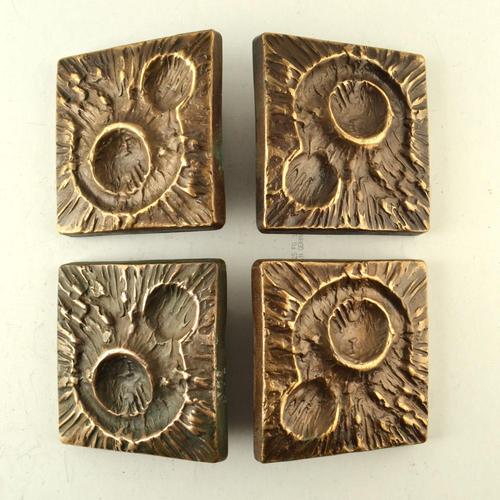 Double pair of bronze door handles with matching letterbox in strong relief like a crater in a landscape. They . These...