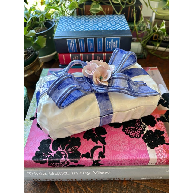 This wonderful ceramic “gift box” features a Trompe L’oeil bow and dainty flowers. The lidded box is white and the bow is...