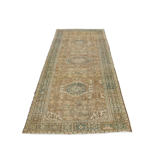 This is a beautiful 20th-century Heriz hand-knotted wool runner with a brown field. The piece boasts stunning blue and...