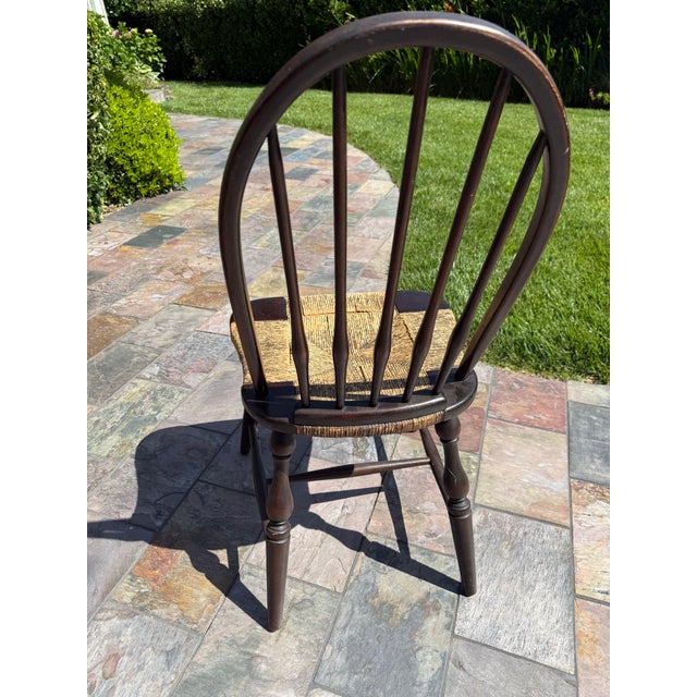 The selected region features a vintage Windsor chair with a rush seat, characterized by its arched spindle back and turned...