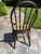 The selected region features a vintage Windsor chair with a rush seat, characterized by its arched spindle back and turned...