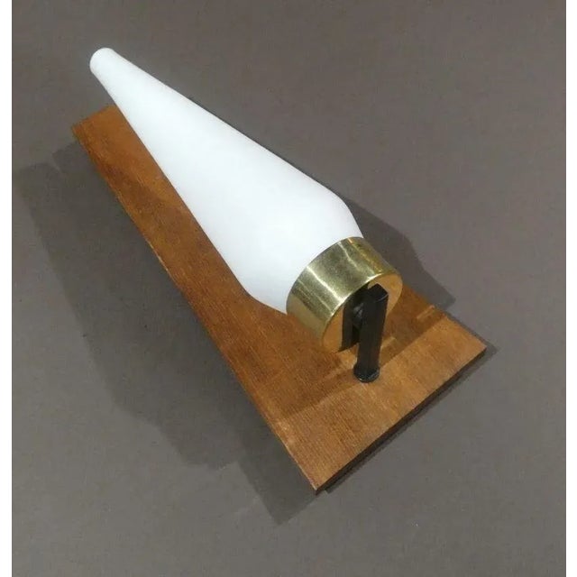 Set of two brass appliques, opal glass and teak wood attributed to stilnovo and produced in the 1950s. the body is in...