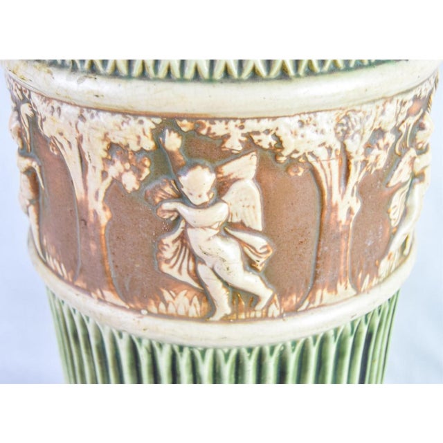 Antique Roseville "Donatello" umbrella stand, circa 1916-1929, measures 20-1/2" tall with a 10" diameter. Crack in base...