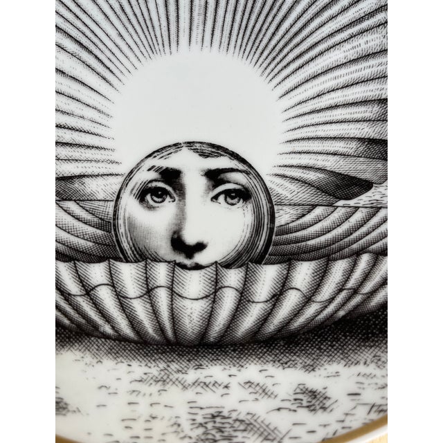 This is a 1980s Fornasetti plate with gold trim.