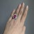 A Madagascar ruby glows in a vivid red at the heart of this solid 14K white gold ring, flanked by fifty-two earth-mined...