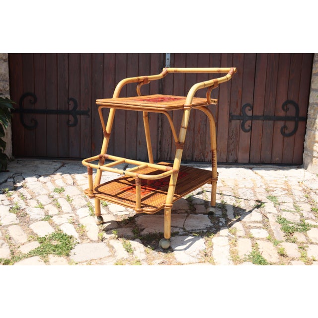Rare two-tiered natural rattan rolling table, attributed to the renowned French design duo Adrien Audoux and Frida Minnet,...