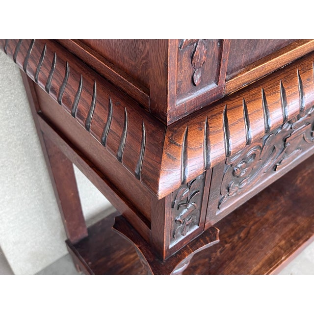20th century Spanish hand carved Renaissance raised cabinet was rendered from dense, old-growth quarter sawn walnut,...