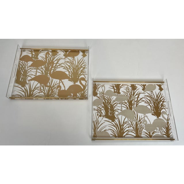 This very beautiful and unusual pair of lucite and brass trays are decorated with gilt birds (some usual scratches on the...