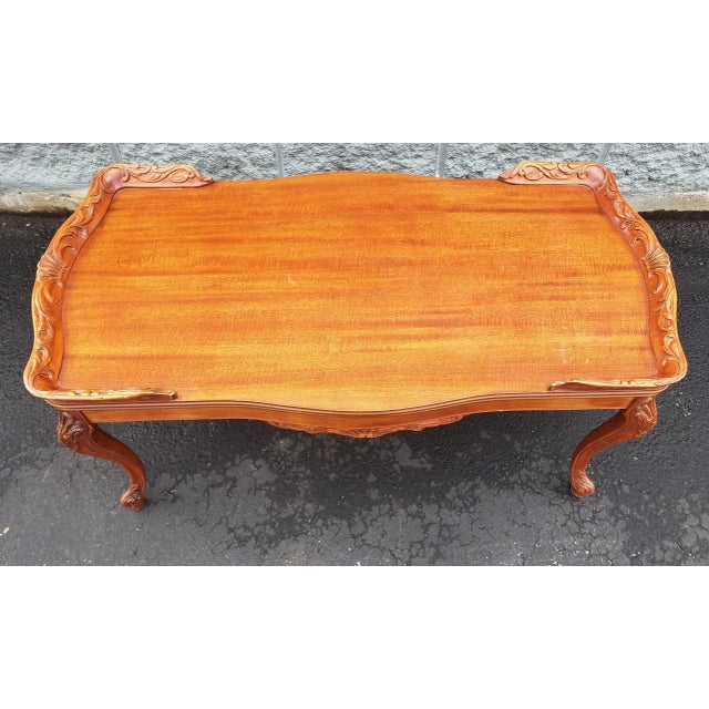 A Louis XVI Style Carved Mahogany Cocktail Table with Solid Mahogany Carved Gallery in very good condition. Measures 40"...