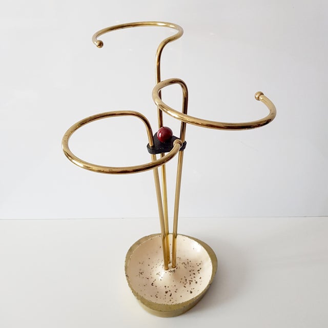 A beautiful umbrella stand from the 1950s with three curved brass brackets. The base plate is made of iron. The umbrella...
