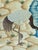 This painting serene natural scene where two graceful cranes stand beside a gently flowing stream. One crane bends...