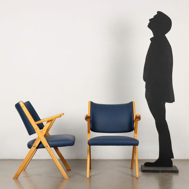 Pair of armchairs with foam padding, skai covering and beech wood structure. This piece is attributed to the mentioned...