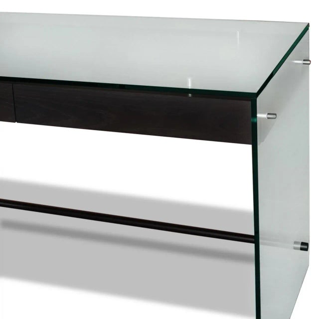 Clear glass Indo desk with simplified form, anodized metal footrest, 2 floating blackened oak-veneered drawers and brand...