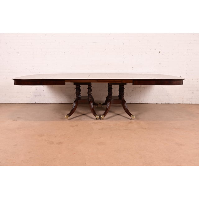 An exceptional Georgian or Regency style double pedestal extension dining table In the manner of Baker Furniture USA,...