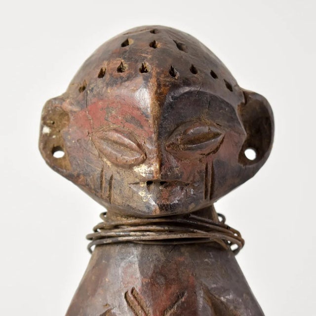 The Songola figure was hand-carved by the Songola people of Congo. This unique piece has cowry shells attached to the...