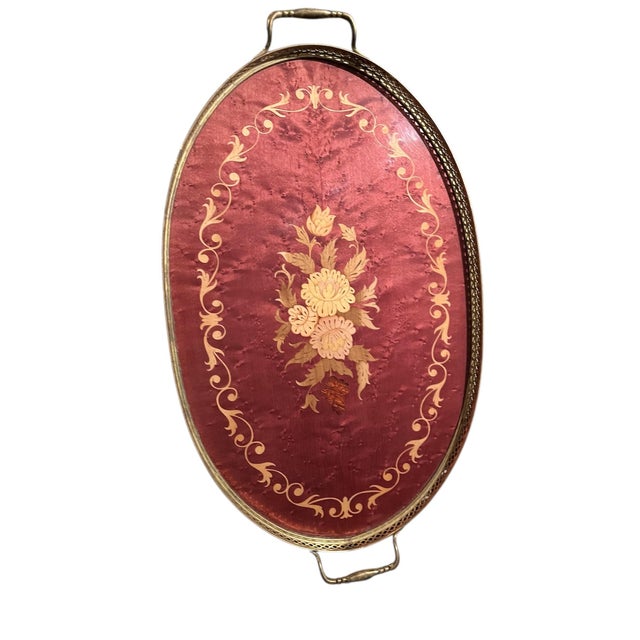 This Italian marquetry inlaid wood floral design serving tray is a handmade piece with a large oval shape and multicolor...