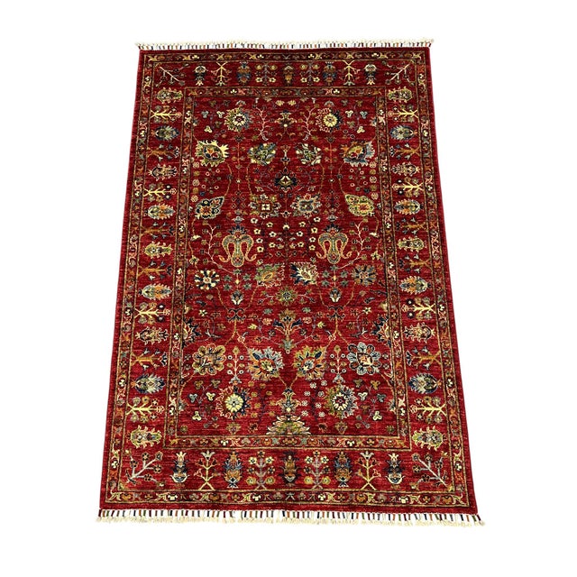 This Sultani-style rug features a Persian-inspired floral design across a deep red field. Flowers, leafy vines, and small...