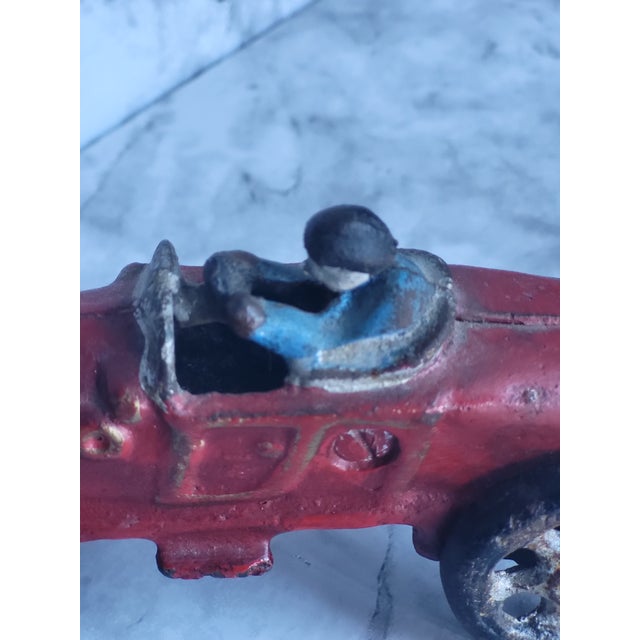 An antique cast iron car toy. The driver is stationary but the wheels move. Wonderful as a display!