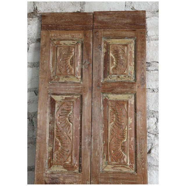 A stunning pair of antique hand-carved wooden French doors celebrating timeless craftsmanship and heritage design. Rich in...