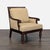 This lounge chair features a sturdy wood frame with carved legs and curved arms. The chair has soft beige cushions for...