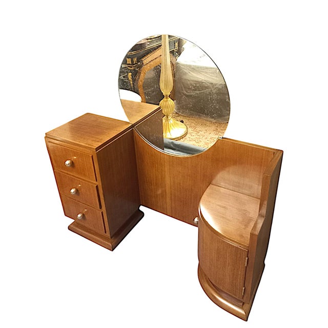 Modernist dressing table from the Art Deco period, circa 1930. It features three drawers and a curved door. It rests on...