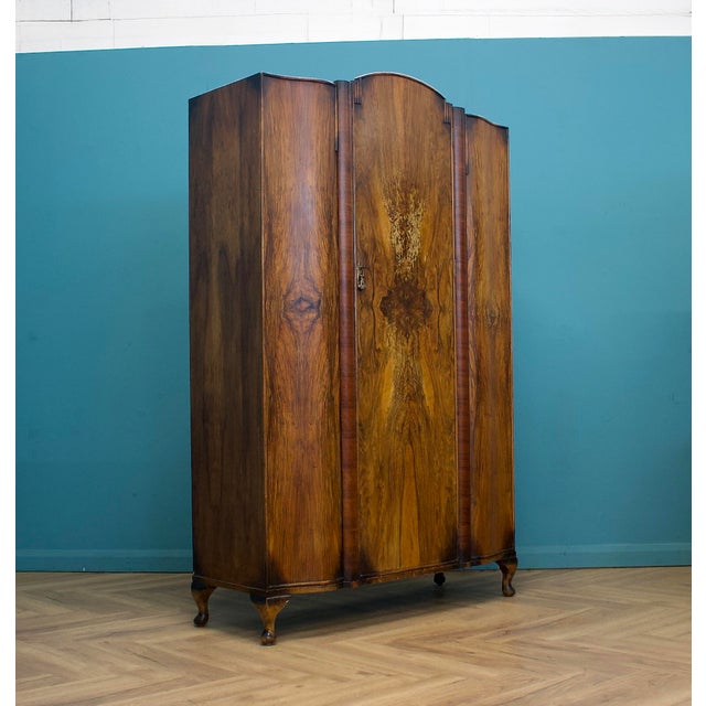 A striking 1930s Art Deco wardrobe in richly figured walnut, with a beautiful bookmatched grain creating a bold central...