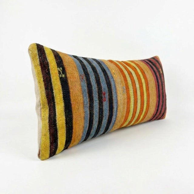 This beautiful 16'' x 47'' pillow cover was made from an authentic Turkish rug. Bright colors of wool adorn the front of...