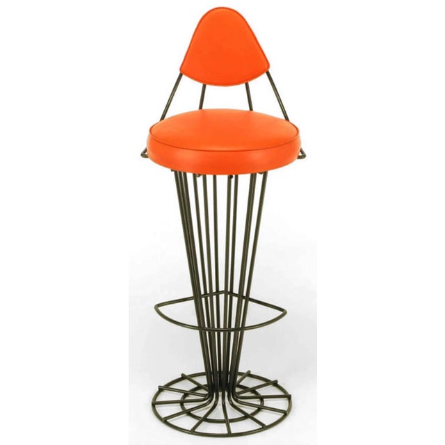 Refinished in a black satin enamel, these unusual iron bar stools consist of skeletal conical pedestals that open to a...