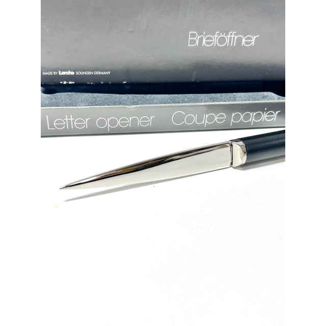 This sleek Lerche Solingen letter opener features a highly polished stainless-steel blade paired with a smooth black...