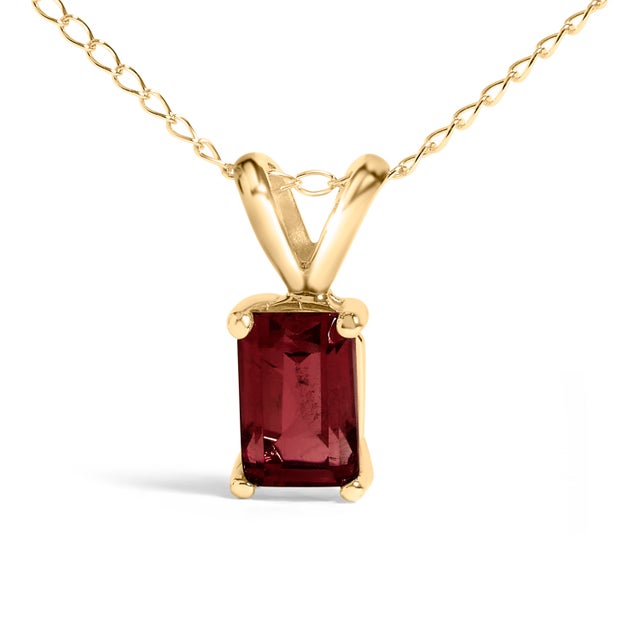 Draped in the regal splendor of a color-enhanced, natural garnet, this 14K yellow gold pendant necklace exudes elegance...