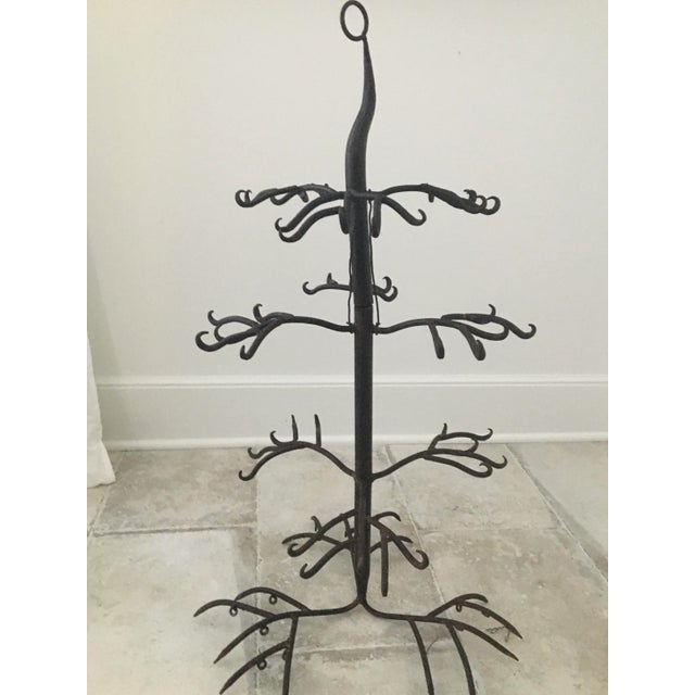 An elegant, artistically constructed, 19th century four-tiered handwrought iron game rack with a center ring for hanging....