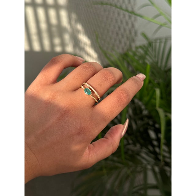 This double band ring features a 0.46 carat of oval cut natural emerald and diamond, set in 14k yellow gold. designed in a...