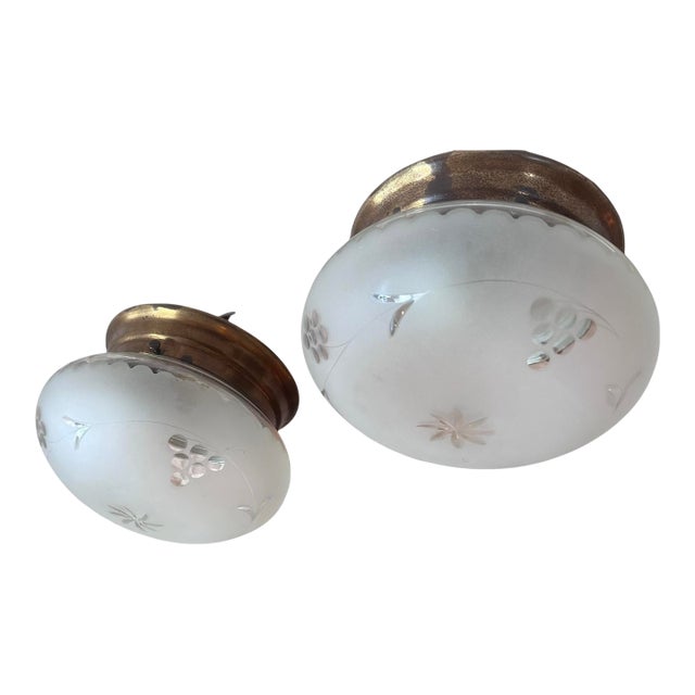1920s American flush mounts with original old brass holders featuring leaves, berries, and star wheel-cut patterns, with frosted glass — a pair For Sale