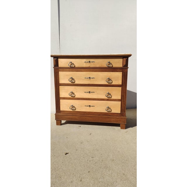 Antique French-made chest of drawers, circa 1950, crafted from solid, light-colored wood. It features four large drawers,...