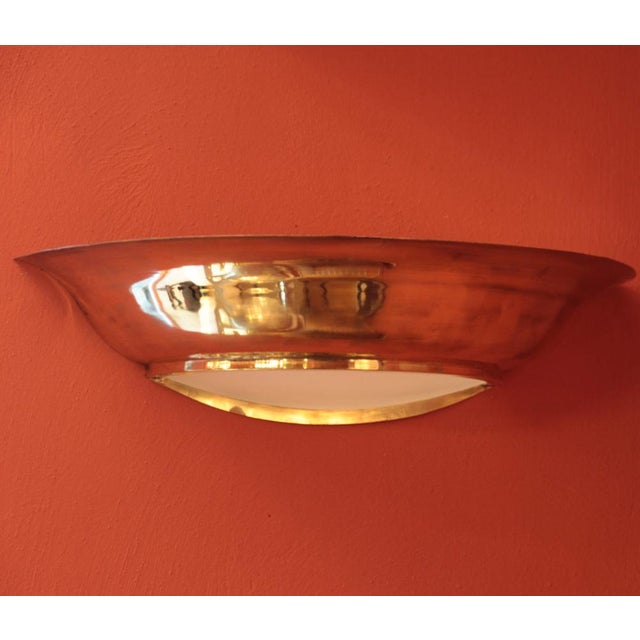 This pair of large wall lights is made of solid brass in the shape of a half bowl. The interior glass is domed and allows...