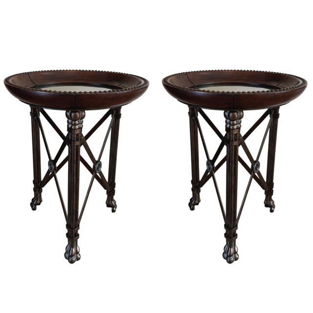 A pair of Regency-style iron and brown leather round glass-top end tables by Maitland Smith. Features exceptional quality...