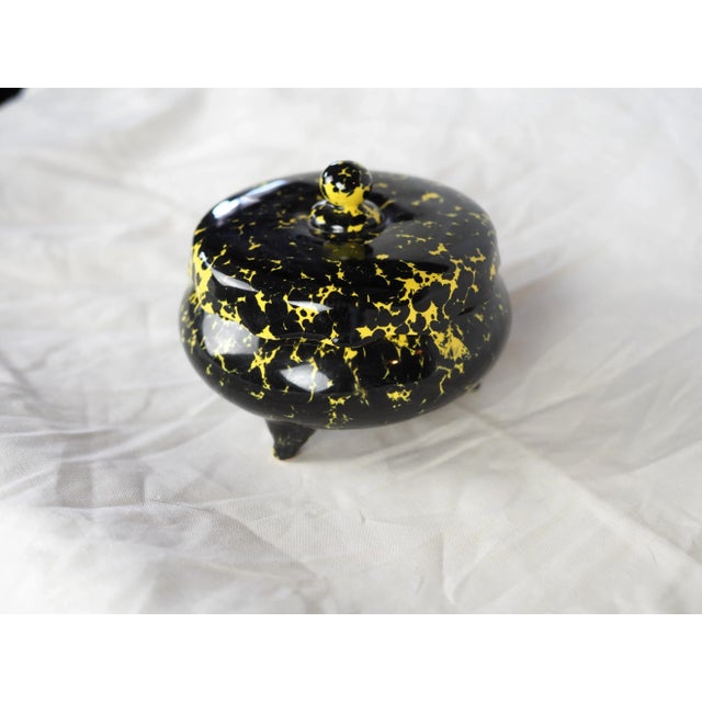 Tripod ceramic box, black and yellow speckled glaze, wavy lid edge and small round handle. This very original and graphic...