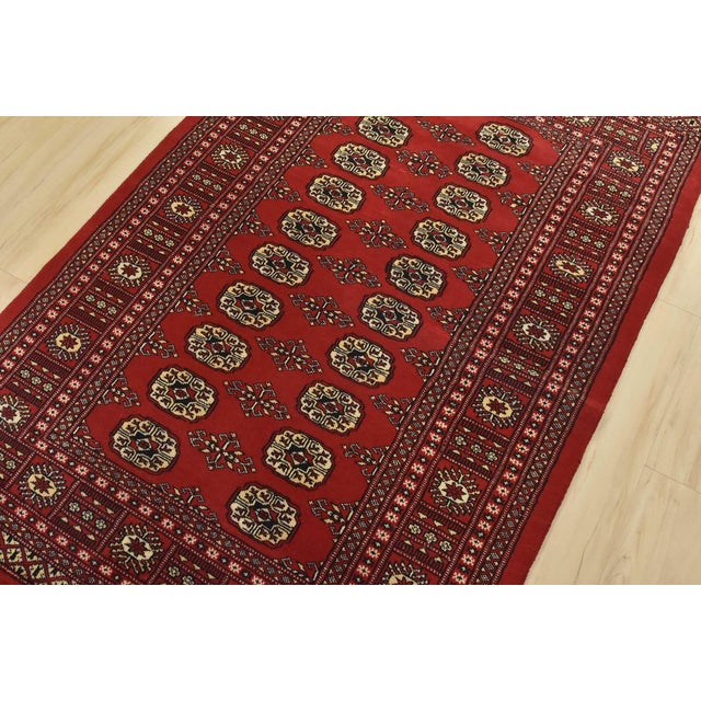 A tribal Bokhara rug hand-knotted with fine wool on a cotton foundation. This rug features rows of repeating medallions...