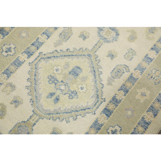 This modern Turkish Oushak rug is a stunning piece of art that has been handwoven using traditional techniques by skilled...