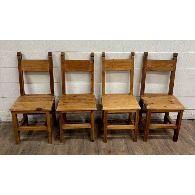 This is a stunning full set of four vintage, possibly antique, Primitive or Rustic style solid pine wood Mexican dining...