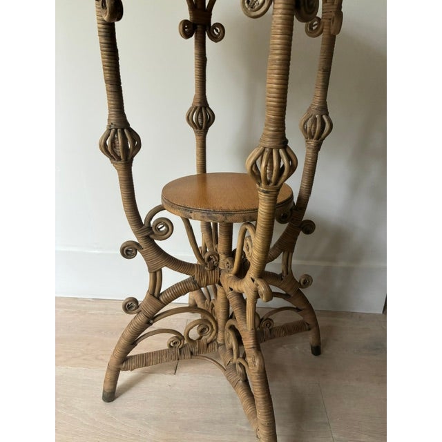 A beautiful pale oak and wicker Victorian table in excellent condition by Heywood Wakefield circa 1910. Stick and ball...