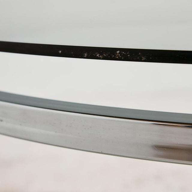 Round shaped coffee table with chrome legs and smoked glass top from the 1970s. with some surface scratches and wear on...