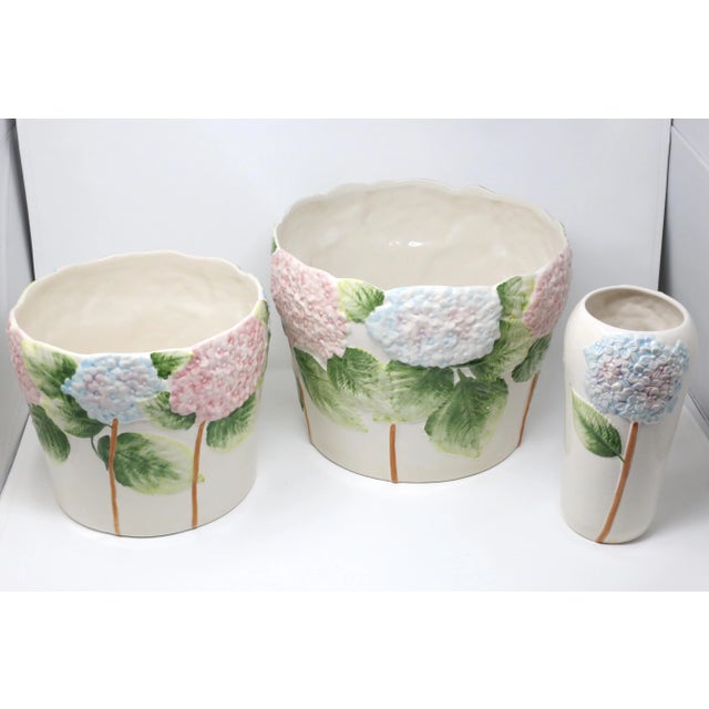 A vintage set of ceramic planters or cachepots and vase, decorated with hand-painted embossed pink and blue hydrangea...